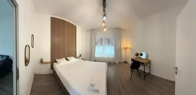 a bedroom with a bed and a desk and a window at Oasis Apartament in Brussels