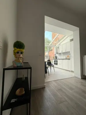 a living room with a table with a plant on it at Oasis Apartament in Brussels