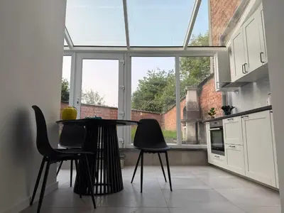 a kitchen with a table and chairs in front of a window at Oasis Apartament in Brussels