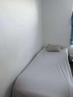 a bed in a room with a white wall at House for TOMMORLAND 700 m in Boom 2850 in Boom