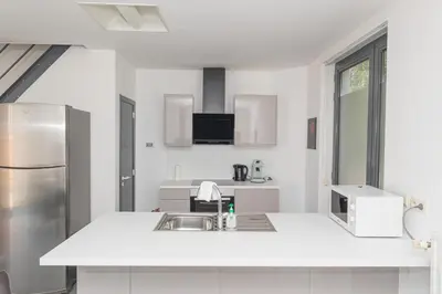 a white kitchen with a sink and a refrigerator at Secret garden