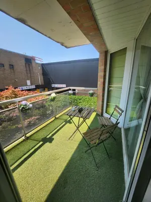 a balcony with a table and chairs on a house at Gezellig verblijf met balkon in Brussels
