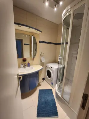 a bathroom with a sink and a washing machine at Gezellig verblijf met balkon in Brussels