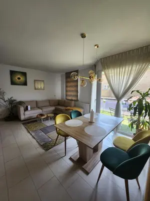 a living room with a table and chairs and a couch at Gezellig verblijf met balkon in Brussels