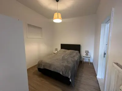 a bedroom with a bed in a white room at Midi Retreat in Brussels