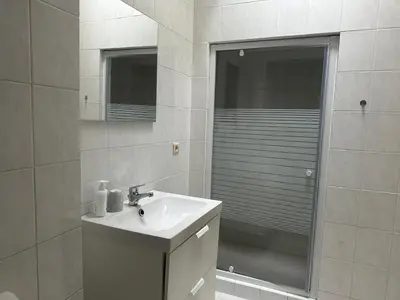 a white bathroom with a sink and a shower at Midi Retreat in Brussels