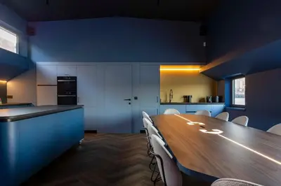 a kitchen with a long wooden table and chairs at Cyberdeck for big groups in Ghent