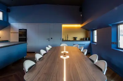 a large wooden table in a kitchen with white chairs at Cyberdeck for big groups in Ghent