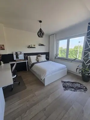 a bedroom with a bed and a desk and a window at Tomorrowland Crib in de buurt van Boom in Schelle