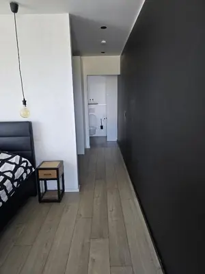 a bedroom with a black wall and a wooden floor at Tomorrowland Crib in de buurt van Boom in Schelle