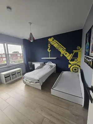 a room with a bed and a yellow crane on the wall at Tomorrowland Crib in de buurt van Boom in Schelle