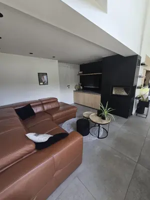 a living room with a brown leather couch and a table at Tomorrowland Crib in de buurt van Boom in Schelle