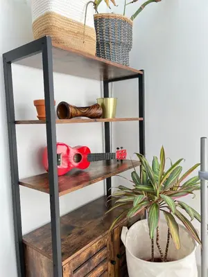 a black shelf with a potted plant and a plant at Tiny House avec terrasse privée, 10 mins du centre in Brussels