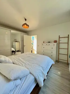 a bedroom with a large white bed and a dresser at Tiny House avec terrasse privée, 10 mins du centre in Brussels
