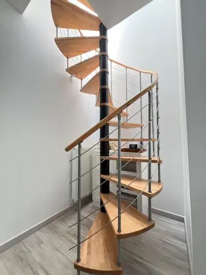 a wooden spiral staircase with metal railings in a room at Tiny House avec terrasse privée, 10 mins du centre in Brussels
