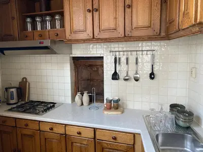 a kitchen with wooden cabinets and a counter top at 18de-eeuwse woning in het hartje van Gent in Ghent