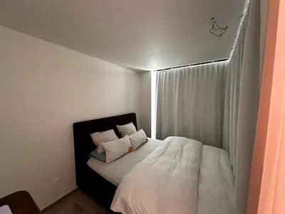 a bedroom with a bed with white sheets and pillows at Studio downtown Gent in Ghent