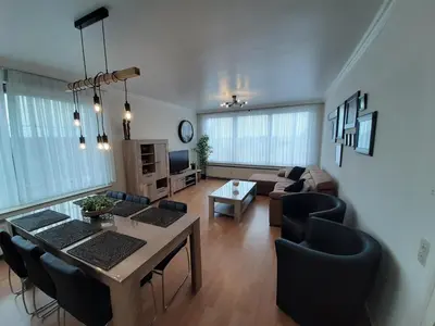 a living room with a couch and a table and chairs at Mazzimmo Boom in Boom