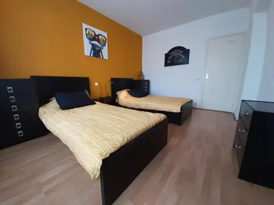 a bedroom with two beds and a dresser at Mazzimmo Boom in Boom