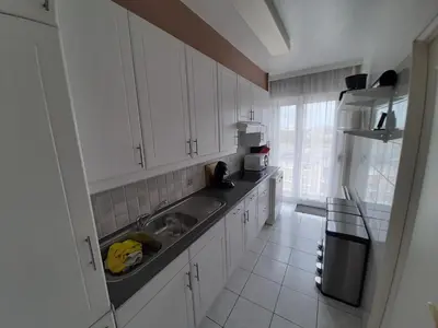 a white kitchen with a sink and a refrigerator at Mazzimmo Boom in Boom
