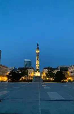 a lit up clock tower in a city at night at Design Studio Brussels Madou in Brussels