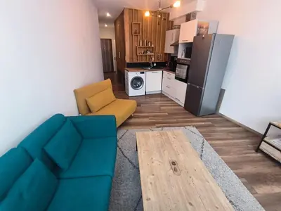 a living room with a blue couch and a kitchen at Design Studio Brussels Madou in Brussels