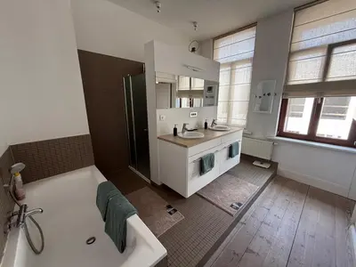a large bathroom with a tub and a sink at Dock Suites in Ghent