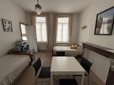 a room with two beds and a table in it at Dock Suites in Ghent
