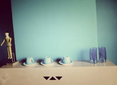 a shelf with cups and vases and a statue at B&B Lieven Bauwens in Ghent