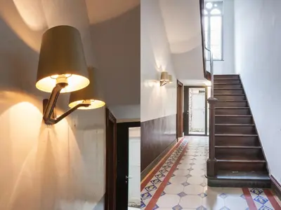 a hallway with a staircase and a lamp on the wall at B&B Pastorie Balegem in Balegem