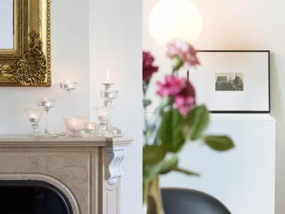 a picture of a fireplace and a vase of flowers at B&B Pastorie Balegem in Balegem