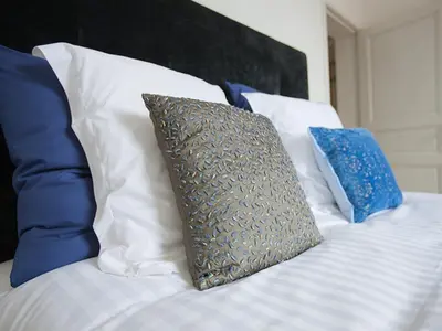 a bed with blue and white pillows and a pillow at B&B Pastorie Balegem in Balegem