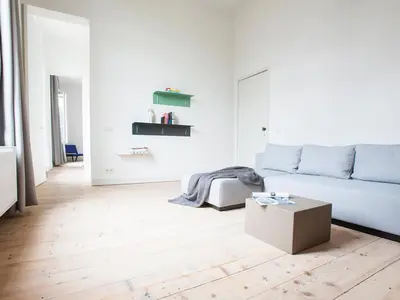 a white living room with a couch and a box at B&B Pastorie Balegem in Balegem