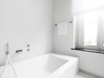 a white bathroom with a tub and a window at B&B Pastorie Balegem in Balegem