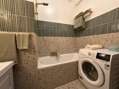 a bathroom with a washing machine and a sink at Sunflora Apartment in Brussels