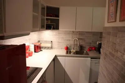 a kitchen with white cabinets and a sink at Sunflora Apartment in Brussels
