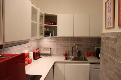a kitchen with white cabinets and a sink at Sunflora Apartment in Brussels