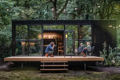a couple of people sitting in a tiny house at Cabins in the woods with wellness in Brasschaat