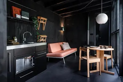 a kitchen with a sink and a table and a chair at Cabins in the woods with wellness in Brasschaat