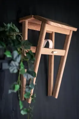 a wooden stool with a plant in front of it at Cabins in the woods with wellness in Brasschaat