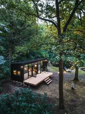 a tiny house in the middle of a forest at Cabins in the woods with wellness in Brasschaat