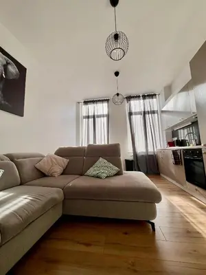 a living room with a couch and a kitchen at Bruxnord BnB in Brussels
