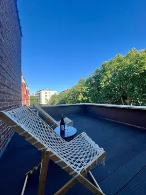 a deck with a table and a bottle of wine at Bruxnord BnB in Brussels
