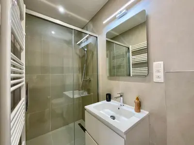 a bathroom with a sink and a shower and a mirror at Chapeliers 34 in Brussels