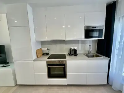 a white kitchen with a sink and a microwave at Chapeliers 34 in Brussels