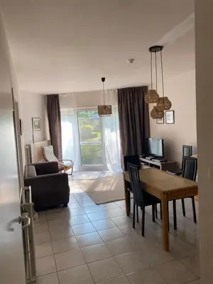 a living room with a table and a dining room at Appartement dans parc