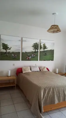 a bedroom with a bed with three pictures on the wall at Appartement dans parc