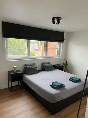 a bedroom with a bed and two windows at Toverpoort - Seperate room in shared apartment in Ghent