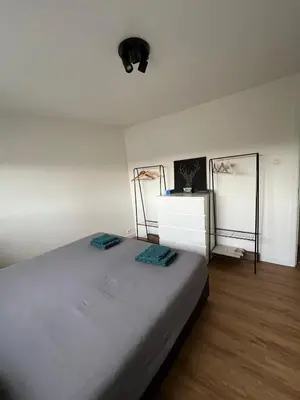 a bedroom with a large bed and a white dresser at Toverpoort - Seperate room in shared apartment in Ghent