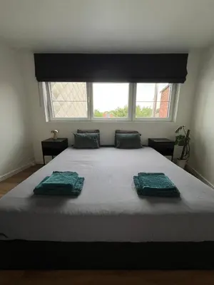 a bedroom with a large bed with two towels on it at Toverpoort - Seperate room in shared apartment in Ghent